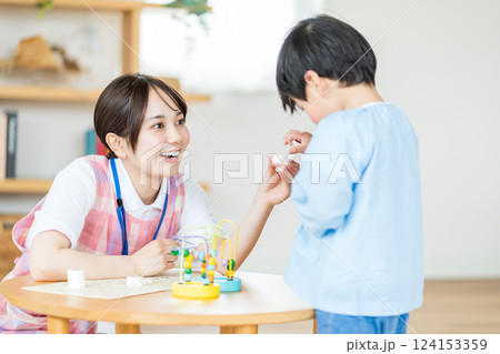 保育園で一緒に遊ぶ保育士の女性と男の子。 124153359
