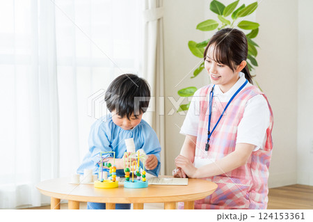 保育園で一緒に遊ぶ保育士の女性と男の子。 124153361