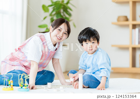 保育園で一緒に遊ぶ保育士の女性と男の子。 保育園で一緒に遊ぶ保育士の女性と男の子。 124153364
