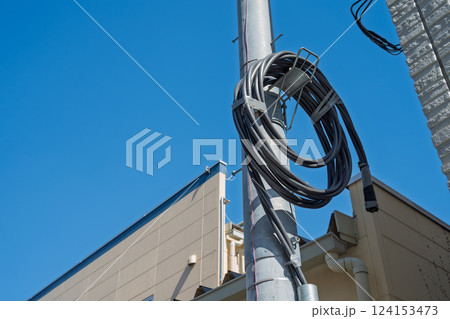 電柱に巻いた黒いケーブル 電柱に巻いた黒いケーブル 124153473