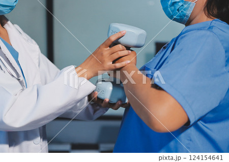 Asian caregiver woman or nurse training senior woman lifting dumbbell for arm exercise while therapy and rehabilitation in living room at home, caretaker or physiotherapist helping elderly workout. 124154641