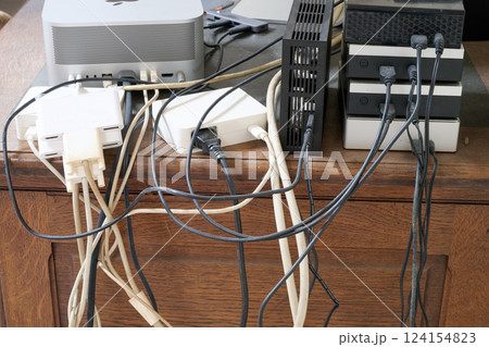 A Lot of messy cables on the floor near wooden desk 124154823