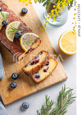 Lemon pie with sugar glaze, blueberries, decorated with rosemary and citrus slices on a wooden board Lemon pie with sugar glaze, blueberries, decorated with rosemary and citrus slices on a wooden board 124155784