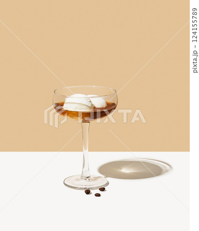 Affogato coffee with vanilla ice cream scoops and espresso in a tall glass on a beige background 124155789