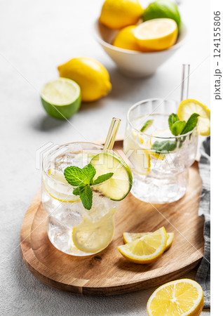 Cocktail or lemonade mojito with fresh lemon, lime, mint and ice on a wooden plate  124155806