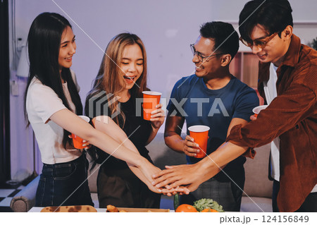 Happy young friends group having lunch at home. Asia family party eating pizza food and laughing enjoying meal while sitting at dining table together at house. Celebration holiday and togetherness. 124156849