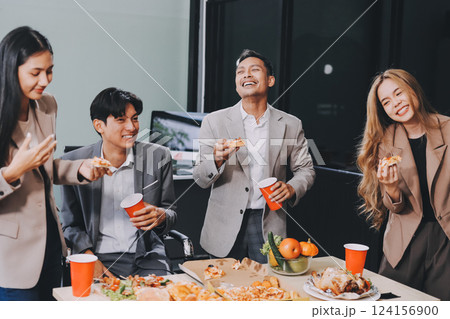 Asian office colleagues and friends enjoy a daytime BBQ with pizza and beer, celebrating Halloween and cheering for their favorite soccer team, creating a lively atmosphere filled with joy. 124156900