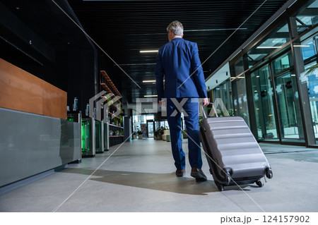 Man with a suitcase going to the exit after arrival to destination 124157902