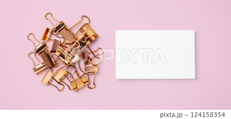 Rose gold binder clips and memo note paper on pastel pink background Rose gold binder clips and memo note paper on pastel pink background 124158354