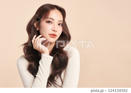 A beautiful young Asian woman with clean, fresh skin against a beige background. Skincare, facial treatment, cosmetology, beauty, and spa. An elegant portrait of an Asian woman. A beautiful young Asian woman with clean, fresh skin against a beige background. Skincare, facial treatment, cosmetology, beauty, and spa. An elegant portrait of an Asian woman. 124158562