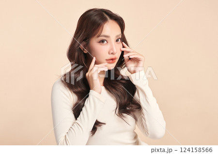 A beautiful young Asian woman with clean, fresh skin against a beige background. Skincare, facial treatment, cosmetology, beauty, and spa. An elegant portrait of an Asian woman. A beautiful young Asian woman with clean, fresh skin against a beige background. Skincare, facial treatment, cosmetology, beauty, and spa. An elegant portrait of an Asian woman. 124158566