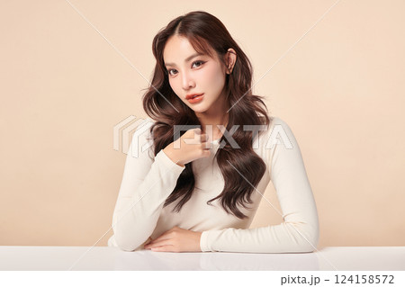 A beautiful young Asian woman with clean, fresh skin against a beige background. Skincare, facial treatment, cosmetology, beauty, and spa. An elegant portrait of an Asian woman. A beautiful young Asian woman with clean, fresh skin against a beige background. Skincare, facial treatment, cosmetology, beauty, and spa. An elegant portrait of an Asian woman. 124158572