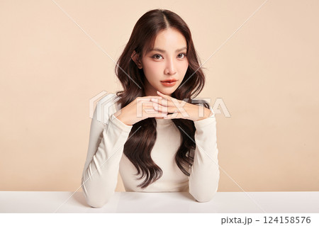 A beautiful young Asian woman with clean, fresh skin against a beige background. Skincare, facial treatment, cosmetology, beauty, and spa. An elegant portrait of an Asian woman. A beautiful young Asian woman with clean, fresh skin against a beige background. Skincare, facial treatment, cosmetology, beauty, and spa. An elegant portrait of an Asian woman. 124158576