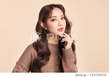 A beautiful young Asian woman with clean, fresh skin against a beige background. Skincare, facial treatment, cosmetology, beauty, and spa. An elegant portrait of an Asian woman. A beautiful young Asian woman with clean, fresh skin against a beige background. Skincare, facial treatment, cosmetology, beauty, and spa. An elegant portrait of an Asian woman. 124158578
