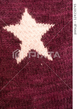 knitted texture, burgundy sweater, or carpet with stars. industrial knitting of clothes made wool. 124158745