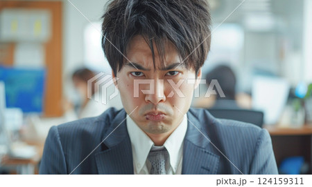 不服そうな顔で見つめる男性 124159311