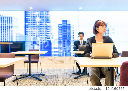 フリーアドレスオフィスで仕事をするヘッドセットをしたビジネスパーソン 124160265