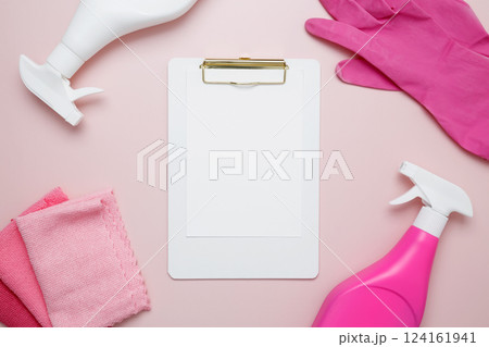 Pink cleaning supplies including rubber gloves, spray bottle, microfiber cloths. Household cleaning and hygiene concept. Mock up clipboard Pink cleaning supplies including rubber gloves, spray bottle, microfiber cloths. Household cleaning and hygiene concept. Mock up clipboard 124161941