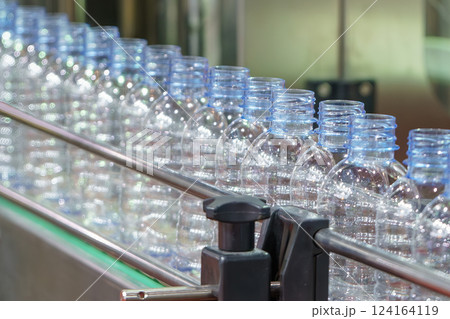 The empty drinking water bottles on the conveyor belt for filling process. The empty drinking water bottles on the conveyor belt for filling process. 124164119