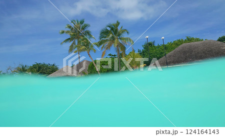 Tropical island paradise emerging from crystal clear turquoise water 124164143