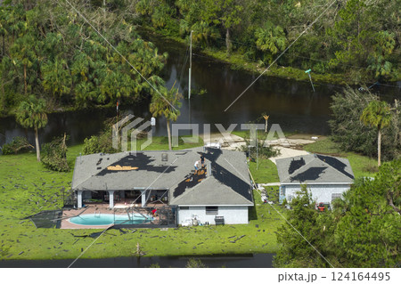 Destroyed house roof by hurricane Ian strong winds in Florida residential area. Natural disaster and its consequences 124164495