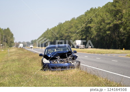 Dented car damaged after traffic accident parked on highway roadside. Transportation hazard concept Dented car damaged after traffic accident parked on highway roadside. Transportation hazard concept 124164508