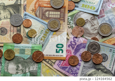 Colorful abstract background made of different metal coins, American, Ukrainian bills and euro banknotes currency. Money and finances, successful investment concept. Colorful abstract background made of different metal coins, American, Ukrainian bills and euro banknotes currency. Money and finances, successful investment concept. 124164562