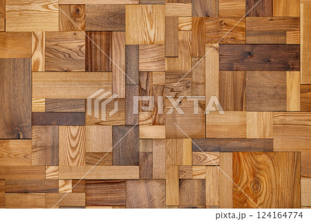 Wooden mosaic artwork showcases a blend of textures and colors in natural tones. 124164774