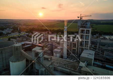 Cement plant with high factory structure and tower cranes at industrial production area. Manufacture and global industry concept 124165606