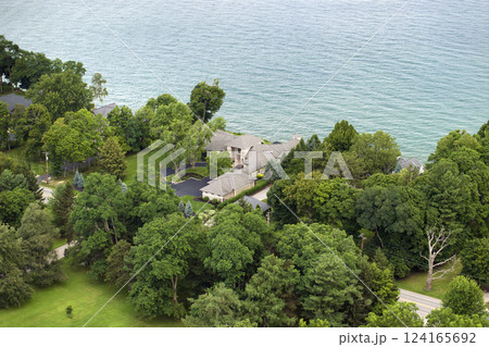 American dream homes on Ontario lakeshore as example of real estate development in US suburbs. View from above of waterfront residential houses in living area in Rochester, NY American dream homes on Ontario lakeshore as example of real estate development in US suburbs. View from above of waterfront residential houses in living area in Rochester, NY 124165692