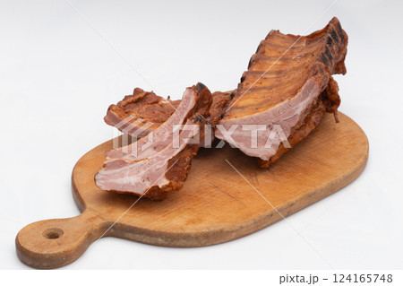 Succulent grilled pork ribs sliced on wooden chopping board isolated on white background 124165748