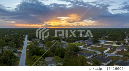 Aerial view of suburban landscape with private homes between green palm trees in Florida quiet residential area in evening 124166034