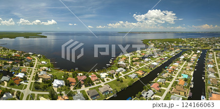 Aerial view of rural private houses in remote suburbs located on sea coast near Florida wildlife wetlands with green vegetation on gulf bay shore. Living close to nature in tropical region concept 124166063