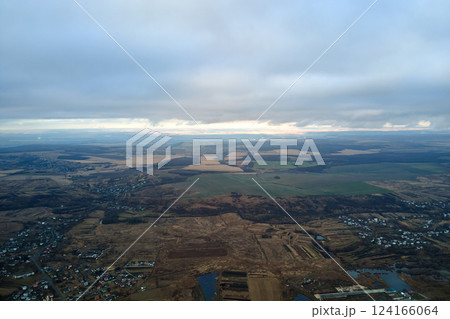 Aerial view of rural homes and distant high rise apartment buildings in city residential area during cloudy weather Aerial view of rural homes and distant high rise apartment buildings in city residential area during cloudy weather 124166064