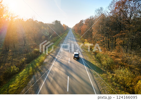 Aerial view of intercity road with blurred fast driving car at sunset. Top view from drone of highway traffic in evening 124166095