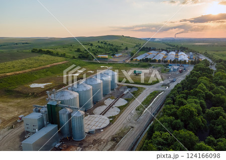 Aerial view of industrial ventilated silos for long term storage of grain and oilseed. Metal elevator for wheat drying in agricultural zone Aerial view of industrial ventilated silos for long term storage of grain and oilseed. Metal elevator for wheat drying in agricultural zone 124166098