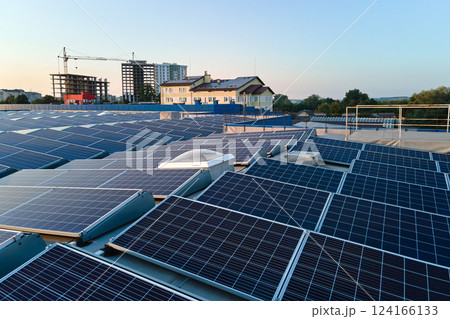 Aerial view of blue photovoltaic solar panels mounted on industrial building roof for producing green ecological electricity. Production of sustainable energy concept Aerial view of blue photovoltaic solar panels mounted on industrial building roof for producing green ecological electricity. Production of sustainable energy concept 124166133