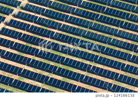 Aerial view of big sustainable electric power plant with many rows of solar photovoltaic panels for producing clean electrical energy. Renewable electricity with zero emission concept Aerial view of big sustainable electric power plant with many rows of solar photovoltaic panels for producing clean electrical energy. Renewable electricity with zero emission concept 124166138