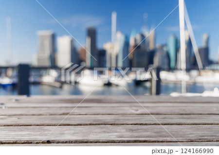 An empty wooden barbecue table set outdoors with a blurred view of the iconic Manhattan skyline 124166990