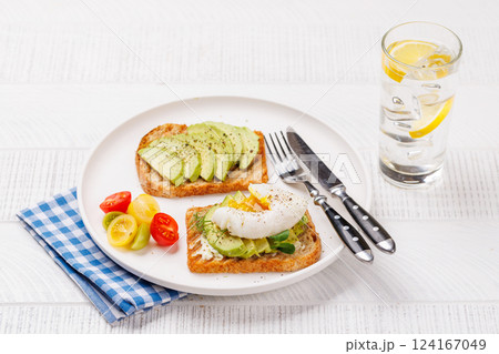 Delicious avocado toasts topped with perfectly cooked poached eggs 124167049
