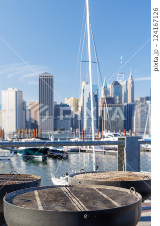 An empty outdoor barbecue grill set against a blurred view of the Manhattan skyline 124167126