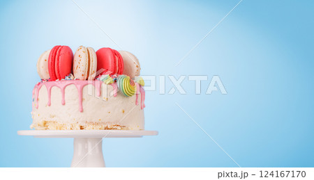 A beautifully decorated cake adorned with colorful macarons 124167170