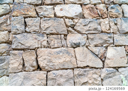 A wall made of stone with a few holes in it A wall made of stone with a few holes in it 124169569