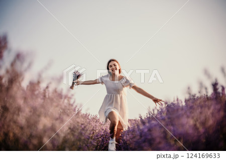 Lavender field happy girl in white dress with a scythe runs through a lilac field of lavender. Aromatherapy travel 124169633