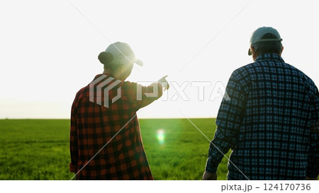 Man and woman farmers colleagues shaking hands at sunset green wheat field closeup. Agricultural workers partners friendly handshaking work as team harvest growth cultivation outdoor sunlight 124170736