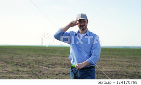 Male farmer smiling with shovel in field. Portrait man on background of field with green fresh corn crops, businessman worker holding shovel smiling broadly contentedly. Fun joyful working as farmer. Male farmer smiling with shovel in field. Portrait man on background of field with green fresh corn crops, businessman worker holding shovel smiling broadly contentedly. Fun joyful working as farmer. 124170769