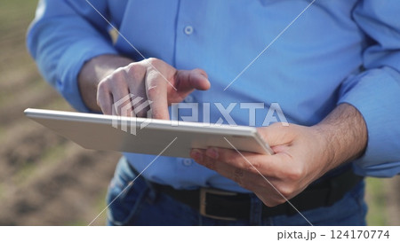 Businessman digital agricultural farmer with tablet. Hands male professional using tablet. Creation planting plans harvest schedules labor allocation aspects of agricultural business farm management. Businessman digital agricultural farmer with tablet. Hands male professional using tablet. Creation planting plans harvest schedules labor allocation aspects of agricultural business farm management. 124170774