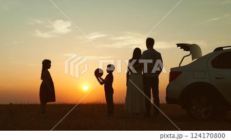 Family at sunset by car in field silhouettes. Children kids plays ball parents hugging enjoying romantic atmosphere happy moment. Importance of Spending Time Together Creating Lasting Family Memories 124170800