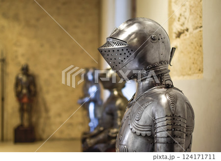 Close up view of Medieval shiny Helmet with details and armors in background Close up view of Medieval shiny Helmet with details and armors in background 124171711