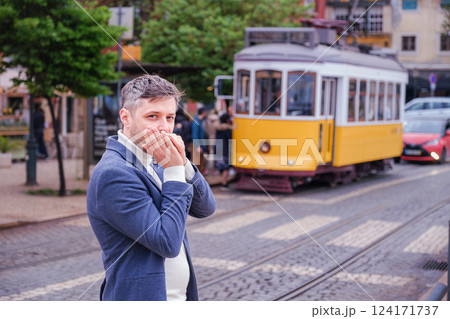 Man plays harmonica outdoors in city street Man plays harmonica outdoors in city street 124171737